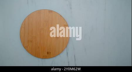 round wooden plate on white kitchen table. Stock Photo