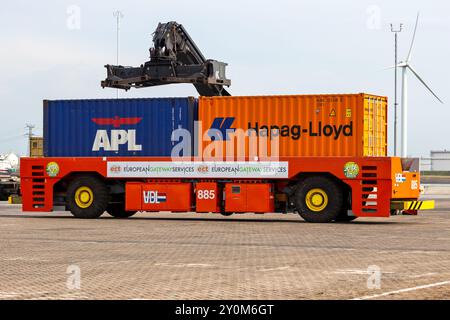 Cargo Container handler placing shipping containers on a automated transport vehicle in the Port of Rotterdam, The Netherlands, September 8, 2013. Stock Photo