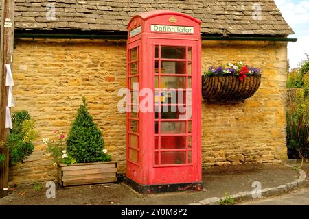 Defibrillator access point in a converted classic red British Phone Box, Cotswolds, Gloucestershire, England, UK Stock Photo