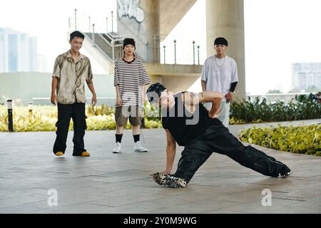 Breakdancer Performing in Urban Setting with Onlookers Stock Photo
