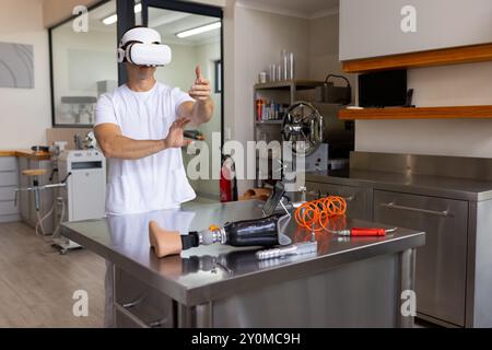 Using VR headset, man in prosthetic lab testing arm movements with equipment, copy space Stock Photo