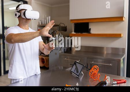 Using VR headset, technician working in prosthetic lab with tablet and tools, copy space Stock Photo