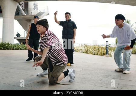 Group of Friends Engaging in Breakdance Moves Outdoors Stock Photo