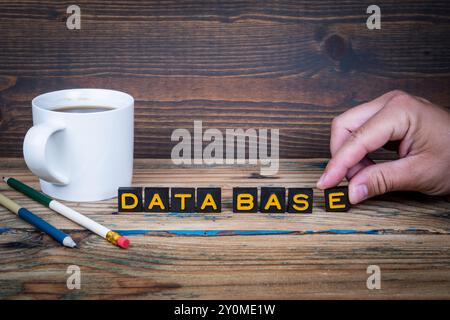DATA BASE. Old letter tiles on a wooden texture office table. Stock Photo