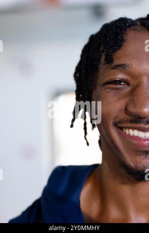 Smiling african american man with braided hair looking at camera, close-up portrait, copy space Stock Photo