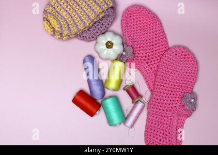 knitted clothes and accessories for needlework on a pink background. Stock Photo