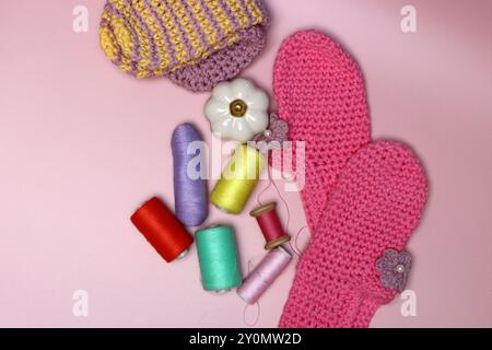 knitted clothes and accessories for needlework on a pink background. Stock Photo