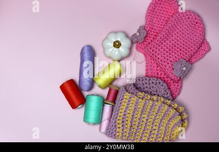 knitted clothes and accessories for needlework on a pink background. Stock Photo