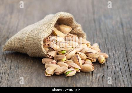 Roasted pistachios in bowl on gray rustic wooden table, healthy nut Stock Photo