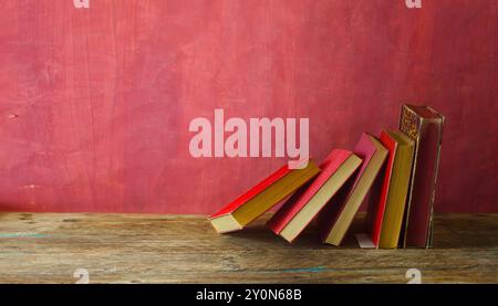 Row of red books on red grungy background, reading, learning, education or home office concept Stock Photo