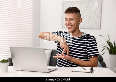 Young man using sign language during video call indoors Stock Photo