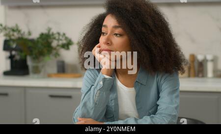 Alone sad upset African American unhappy woman biracial negative sadness mood girl lonely stress thinking boring pensive in home modern kitchen ethnic Stock Photo