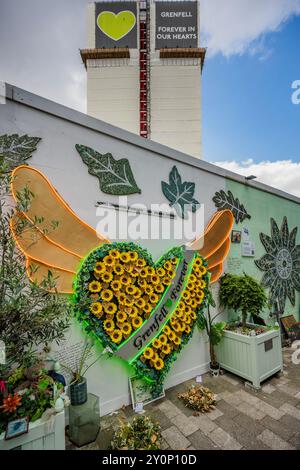 London, UK. 3rd Sep, 2024. Life goes on around the memorial wall (which includes a winged heart made up of messages on sunflowers), as the tower looms above, on the day before the report on the Grenfell Tower disaster is released. Those involved remain upset and frustrated that no-one has been called to account for the tragedy and hope this may change after tomorrow. Credit: Guy Bell/Ģ����ý Live News Stock Photo
