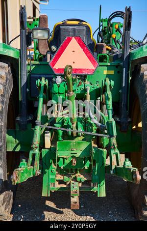 Rear view of modern agricultural tractor in hangar. Hydraulic hitch ...