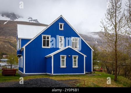 Traditional Icelandic blue residential building with white window frames, cladded in corrugated metal sheets in Seydisfjordur town in Iceland. Stock Photo