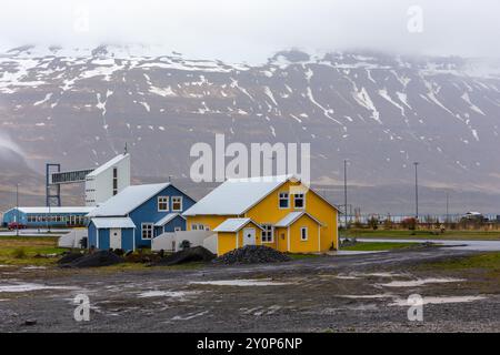 Seydisfjordur town in Iceland with traditional Icelandic colorful residential buildings, snowcapped mountains and ferry terminal in the background. Stock Photo