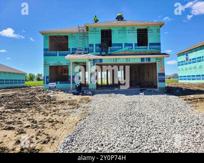 Residential Construction Site with Workers on Roof - Eye-Level Perspective Stock Photo