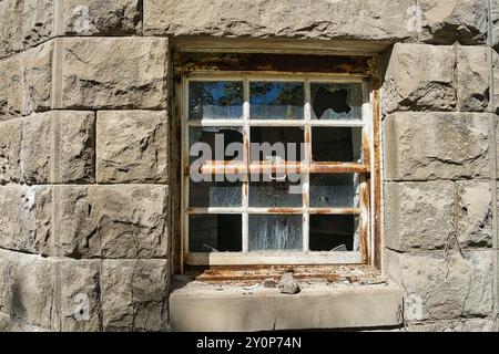 Old broken window of a stone building Stock Photo