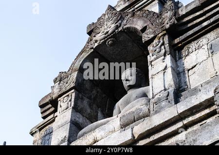 Ancient buddha statue is sitting peacefully inside borobudur temple, a unesco world heritage site in java, indonesia Stock Photo