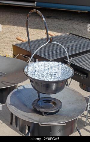 Enamelled metal cauldron pot with handle outside in countryside Stock Photo