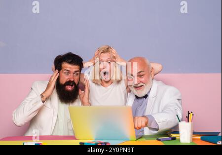 Shocked group of business people. Businesspeople sharing their ideas. Shocked Business team looking at laptop. Stock Photo