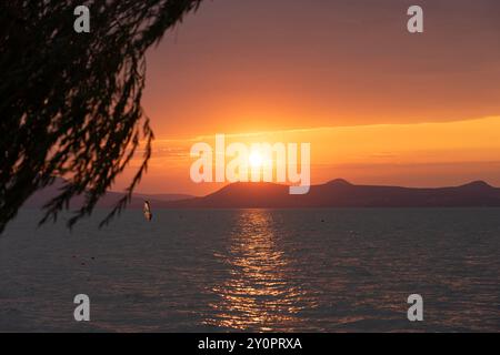 beautiful sunset over Lake Balaton with a woman windsurfing Stock Photo