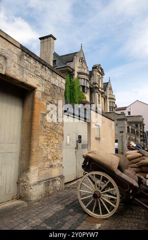 View of wooden wheel on cart laden with hessian sacks on a cobbled lane  street on film set in Oxford City England UK 2024  Great Britain KATHY DEWITT Stock Photo