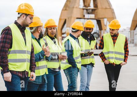Maritime industry workers, Engineer team working at dock warehouse for transport services. Multiracial people at logistic construction Stock Photo