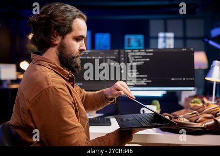 Programmer closing laptop, ready to go home after designing and developing software applications. IT professional packing notebook after implementing and maintaining company systems Stock Photo
