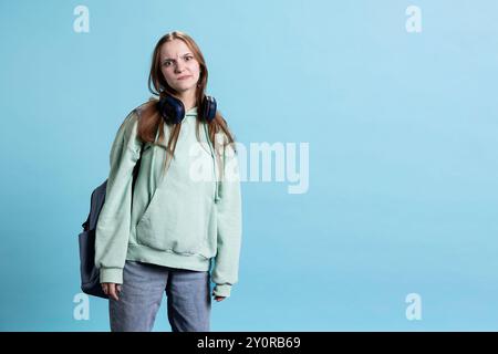 Young actress goofing around, switching emotions, trying different facial expressions, practicing for theatre class, isolated over studio background. Teenage woman making silly faces, Stock Photo