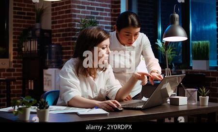Employee asking for help from coworker after being stuck on difficult project task. Worker in brick wall office requesting assistance from knowledgeable colleague, writing email to business partner Stock Photo