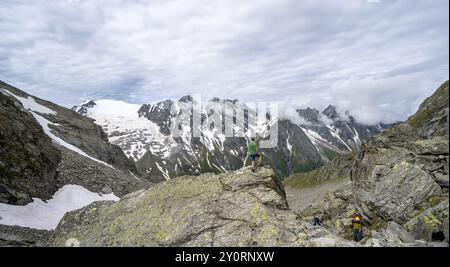 Mountaineer in a rocky saddle, Lapenscharte with view of mountain peaks and glacier into the valley Floitengrund, Berliner Hoehenweg, Zillertal Alps, Stock Photo