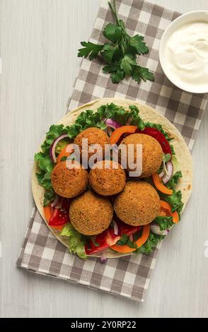 Tortillas, wrapped falafel balls, with fresh vegetables, vegetarian healthy food, on a wooden white background, no people, selective focus Stock Photo