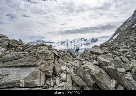 Mountaineer in a rocky saddle, Lapenscharte with view of mountain peaks, Berliner Hoehenweg, Zillertal Alps, Tyrol, Austria, Europe Stock Photo