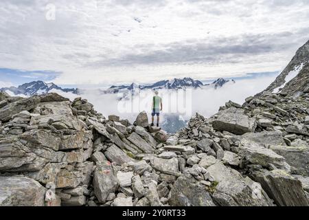 Mountaineer in a rocky saddle, Lapenscharte with view of mountain peaks, Berliner Hoehenweg, Zillertal Alps, Tyrol, Austria, Europe Stock Photo