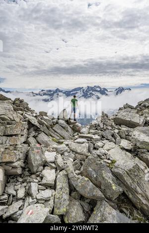 Mountaineer in a rocky saddle, Lapenscharte with view of mountain peaks, Berliner Hoehenweg, Zillertal Alps, Tyrol, Austria, Europe Stock Photo