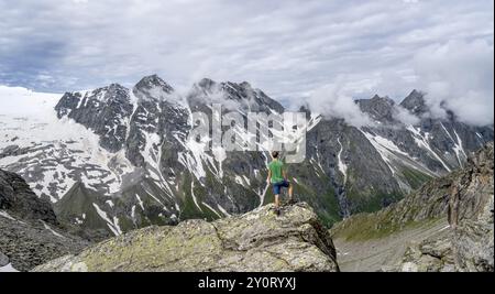 Mountaineer in a rocky saddle, Lapenscharte with view of mountain peaks and glacier into the valley Floitengrund, Berliner Hoehenweg, Zillertal Alps, Stock Photo