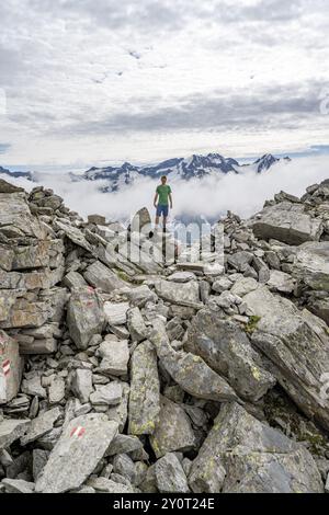 Mountaineer in a rocky saddle, Lapenscharte with view of mountain peaks, Berliner Hoehenweg, Zillertal Alps, Tyrol, Austria, Europe Stock Photo