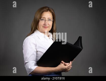 Portrait of a mature professional woman holding a document binder Stock Photo
