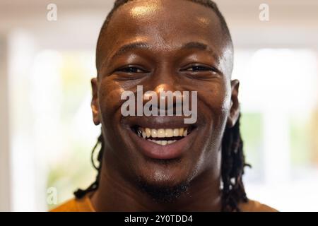 Smiling African American man with braided hair looking at camera, showing happiness and confidence Stock Photo