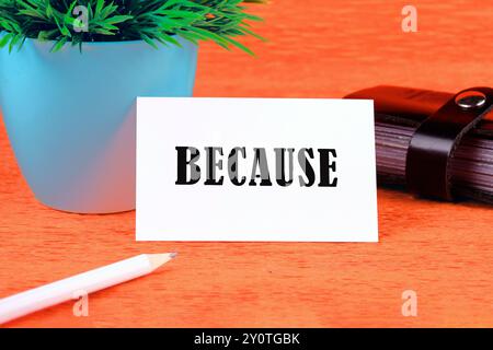 Word BECAUSE on a white business card on an orange background Stock Photo