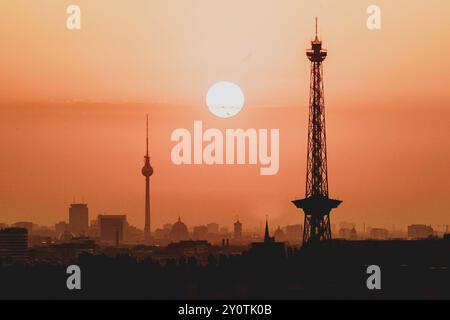 Der Sonnenaufgang zeichnet sich ab hinter der Stadtsilhouette mit dem Fernsehturm und dem Funkturm in Berlin, 04.09.2024. Berlin Deutschland *** The s Stock Photo