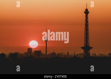 Der Sonnenaufgang zeichnet sich ab hinter der Stadtsilhouette mit dem Fernsehturm und dem Funkturm in Berlin, 04.09.2024. Berlin Deutschland *** The s Stock Photo