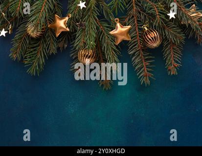 Fir branch with Christmas decorations on a  dark blue-green painted wooden background.  Flat lay.  New Year and Christmas  background. Stock Photo