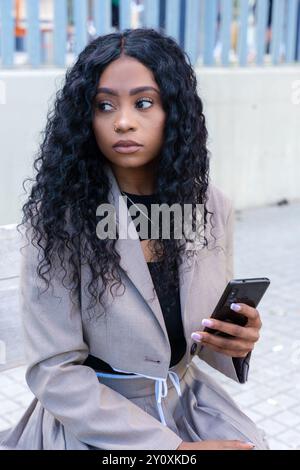 Young serious African American woman browsing the Internet with smart mobile application  Stock Photo