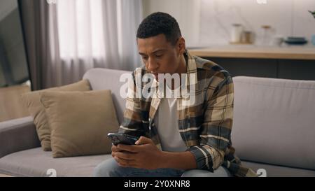 Tired African American man exhausted biracial male worried anxiety ethnic guy stress pensive thinking thoughtful think problem read bad news trouble Stock Photo