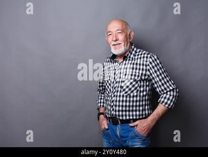 Serious senior man posing with hands on hips Stock Photo