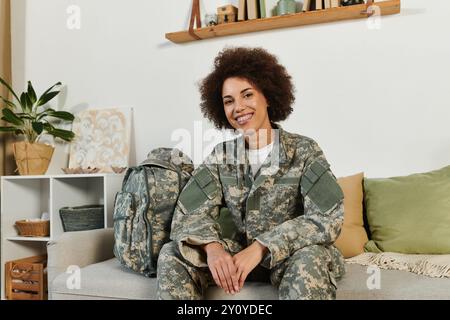 A young woman in military attire sits comfortably in her living room, preparing for her upcoming service. Stock Photo