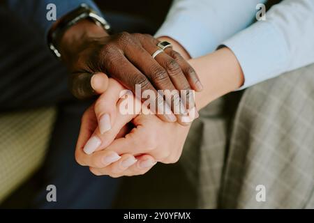 Interracial Couple Holding Hands with Wedding Rings Stock Photo