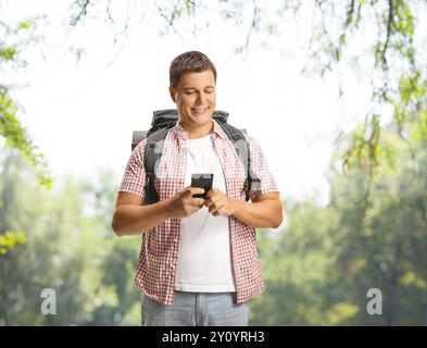 Guy with a backpack using a smartphone outdoors Stock Photo